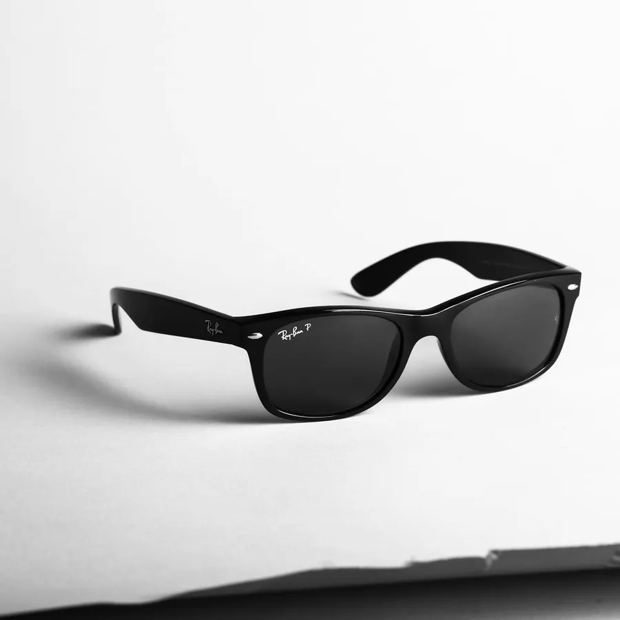 A pair of black sunglasses resting on a paper background
