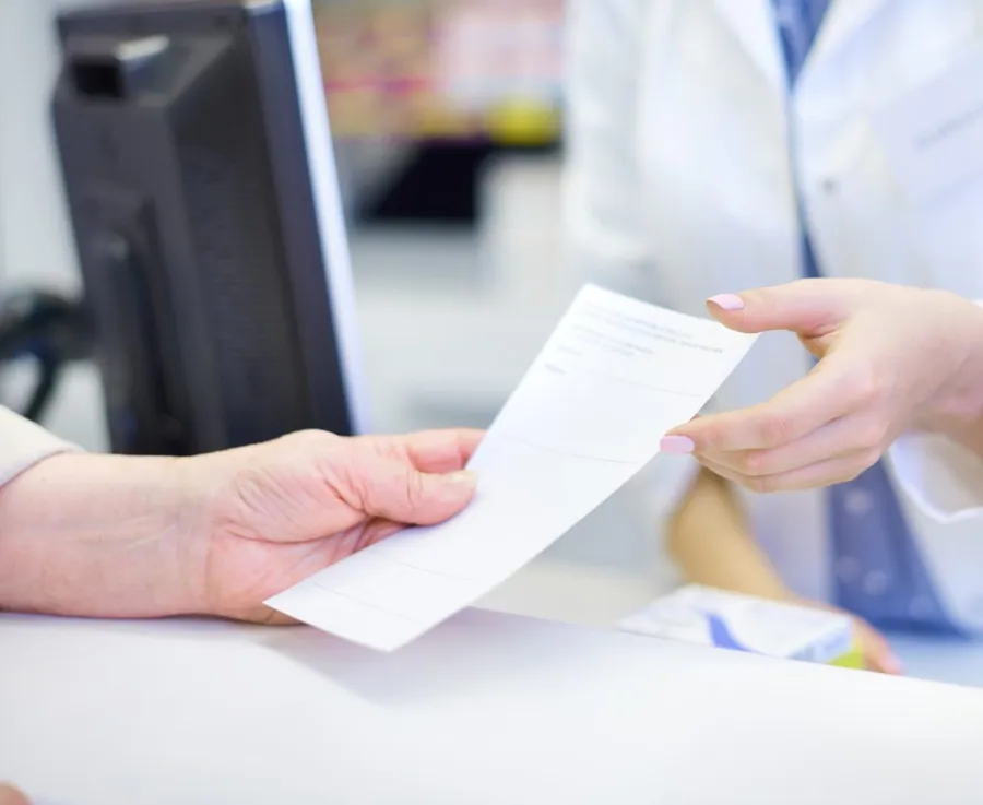 A prescription being handed across a counter